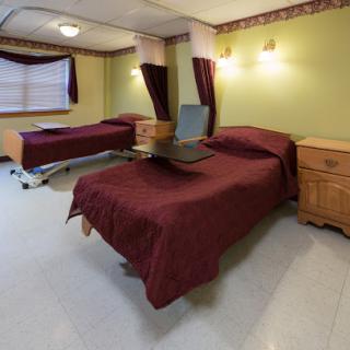 A well-appointed hospital room featuring two beds and warm lighting.