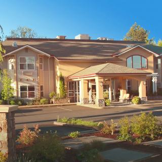 A sunny view of a large residential building with well-maintained landscaping.