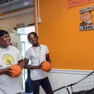 Two people enjoying a game of basketball in an indoor setting.