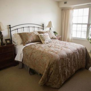 A cozy bedroom with a neatly made bed and elegant decor.