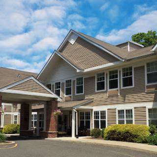 A modern residential building with a welcoming entrance under a bright sky.