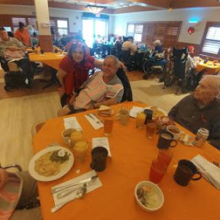 A lively gathering of seniors enjoying a mealtime together at a community center.