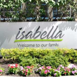 A welcoming sign with flowers in a garden setting.