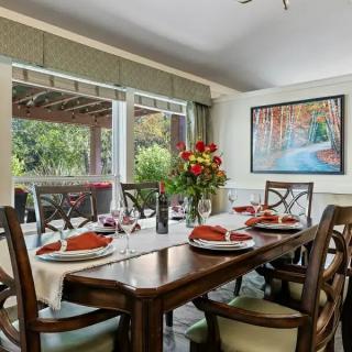 A beautifully set dining table in a well-lit room with large windows and elegant decor.