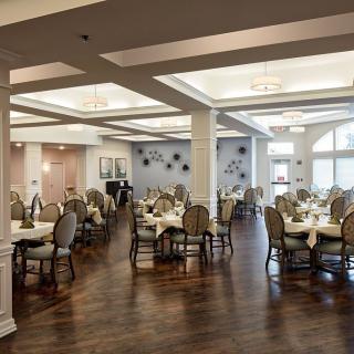 Elegant dining area with neatly arranged tables and chairs, featuring stylish interior decor and warm lighting.