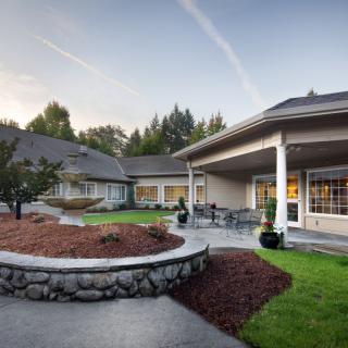 A well-maintained residential building with a landscaped garden and outdoor seating area.
