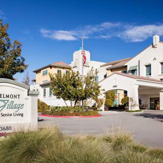 A residential building with an entrance and sign under a clear blue sky.