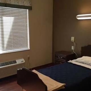 A simple hospital room with a bed and window.