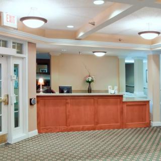 A well-lit reception area with a wooden desk and floral decor.