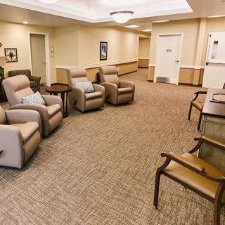 A cozy waiting room with several recliner chairs and a carpeted floor.