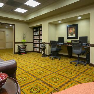 A neatly organized office space with two computer workstations and patterned carpeting.