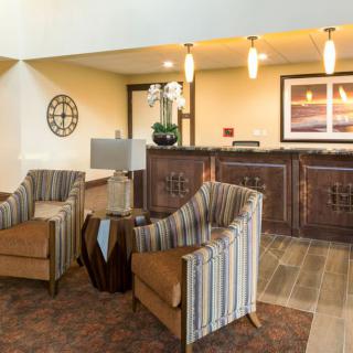 A cozy hotel lobby with seating area and reception desk.