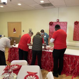 Volunteers preparing for a festive community event with holiday decorations.