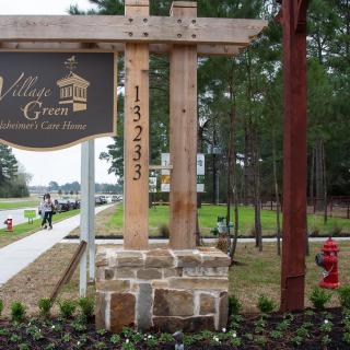 Entrance sign to a suburban neighborhood with trees and landscaping.