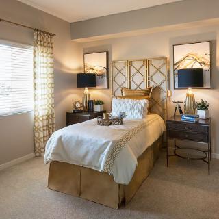A cozy and elegantly designed bedroom with a single bed, soft lighting, and warm decor accents.