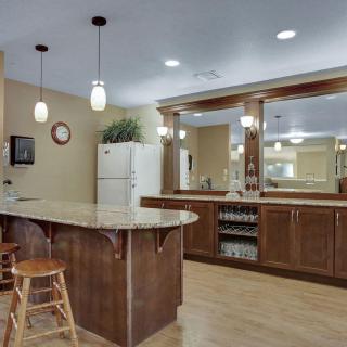 A modern kitchen with wooden cabinets, pendant lighting, and a spacious island.