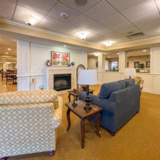 A cozy living room with comfortable seating, a fireplace, and warm lighting.