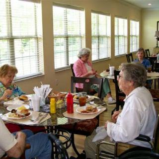 A group of elderly individuals enjoying a meal together in a communal dining area.