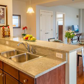 A modern kitchen with a spacious countertop and sink in an open concept home.