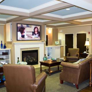 A cozy living room with comfortable seating, a fireplace, and a television.