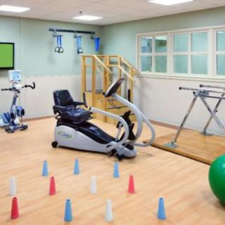 A rehabilitation room equipped with various exercise and therapeutic devices for physical therapy.