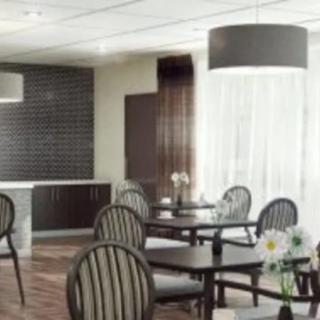 A modern dining area with round tables and striped chairs, featuring elegant lighting and decor.