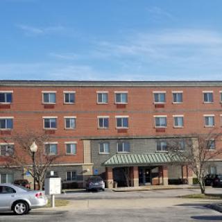 A brick hotel building with a green awning, showcasing urban architecture during the day.