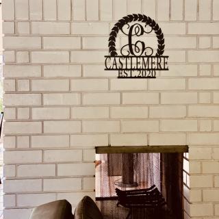 A cozy living room with a brick fireplace and a decorative metal sign above it.