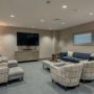 A modern living room with a large television, comfortable seating, and stylish decor.