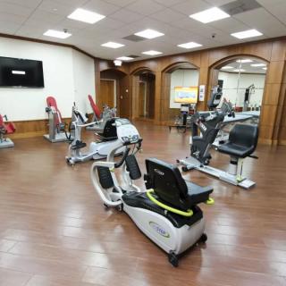 A well-equipped gym with stationary exercise bikes and wood flooring.