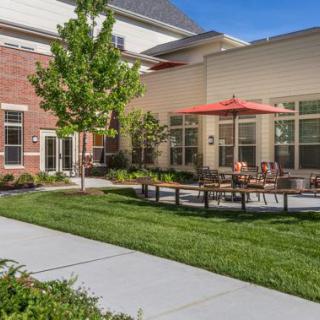 A modern building with a well-maintained courtyard and outdoor seating area.