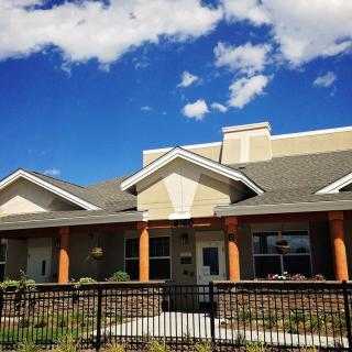 Suburban house under a blue sky with clouds.