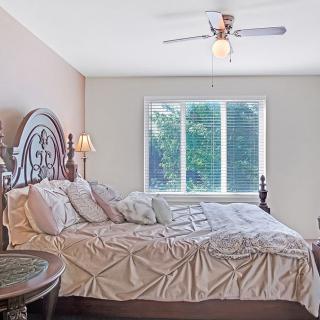 A cozy bedroom with a large bed and natural light from the window.