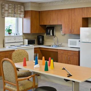 A kitchen area with wooden cabinets, a refrigerator, and a table with colorful cones.