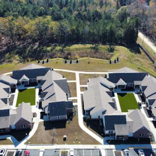 Aerial view of a well-planned residential community featuring multiple housing units and landscaped areas.