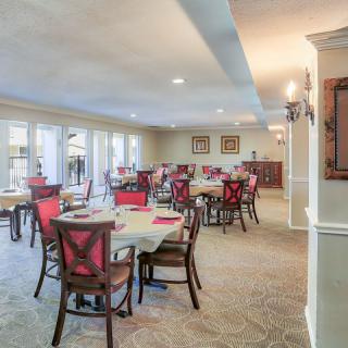 A spacious and elegantly furnished dining area with neatly arranged tables and chairs.