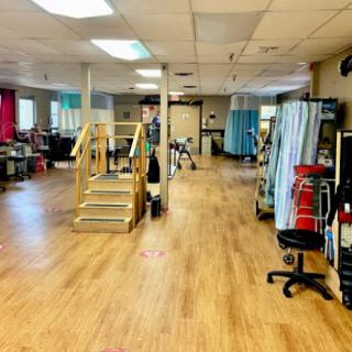A spacious rehabilitation center equipped with therapy and exercise equipment.