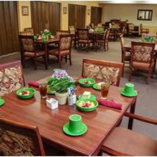 A dining room decorated for St. Patrick's Day with green hats and neatly set tables.