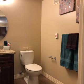 A neatly organized bathroom with a toilet, sink, and towels.