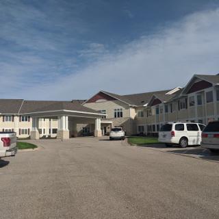A view of a hotel with a parking area on a cloudy day.