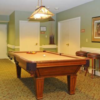 A cozy game room featuring a pool table and warm lighting.