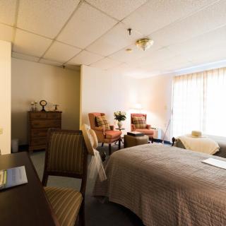 A cozy bedroom with comfortable furnishings and ample natural light.