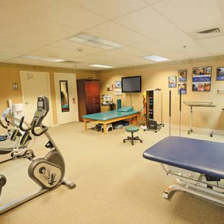 A therapy room equipped with stationary bikes and treatment tables for physical rehabilitation.