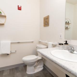 A minimalist bathroom with a toilet, sink, and mirror.