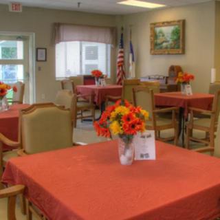 A cozy dining room setup with red tablecloths and floral centerpieces.