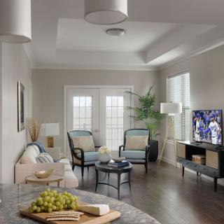 A modern living room with elegant furniture, a TV, and natural lighting.