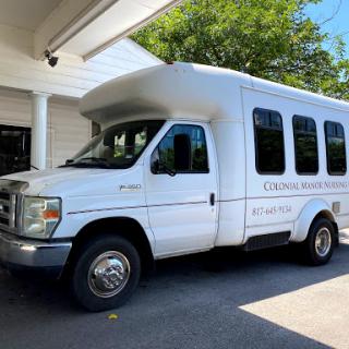 A white shuttle bus parked in a lot, ready for transport.