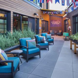 A modern outdoor patio with comfortable seating and decorative flags.