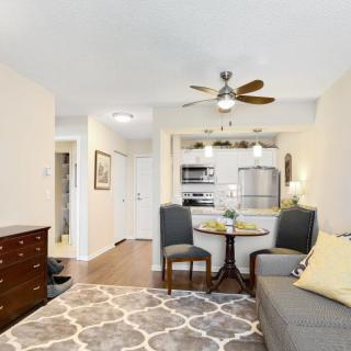 A modern living space featuring a small dining area and open kitchen.