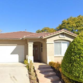 A suburban house with a garage and a well-maintained front yard on a sunny day.